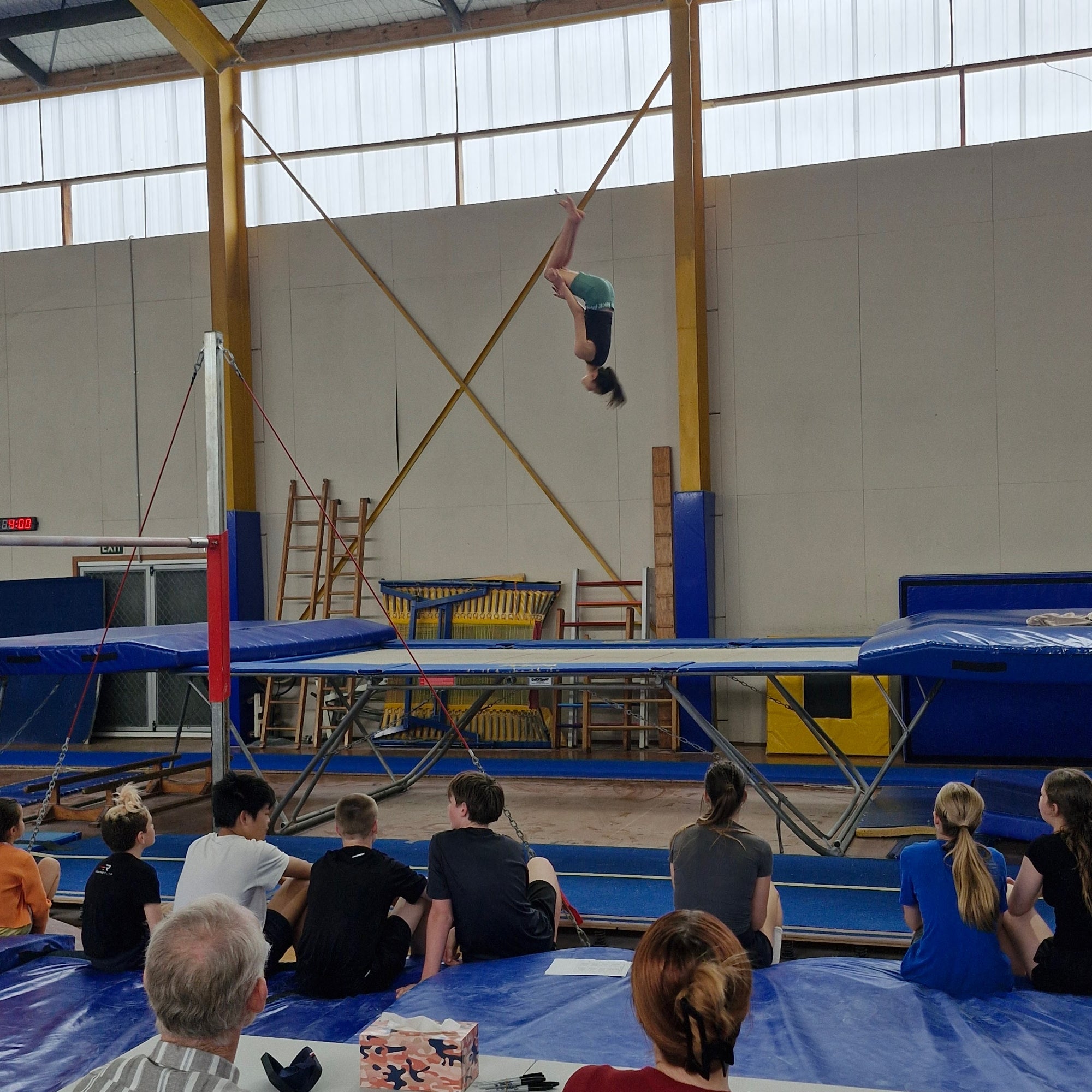 Girl jumping high doing a back flip during trampoline competition